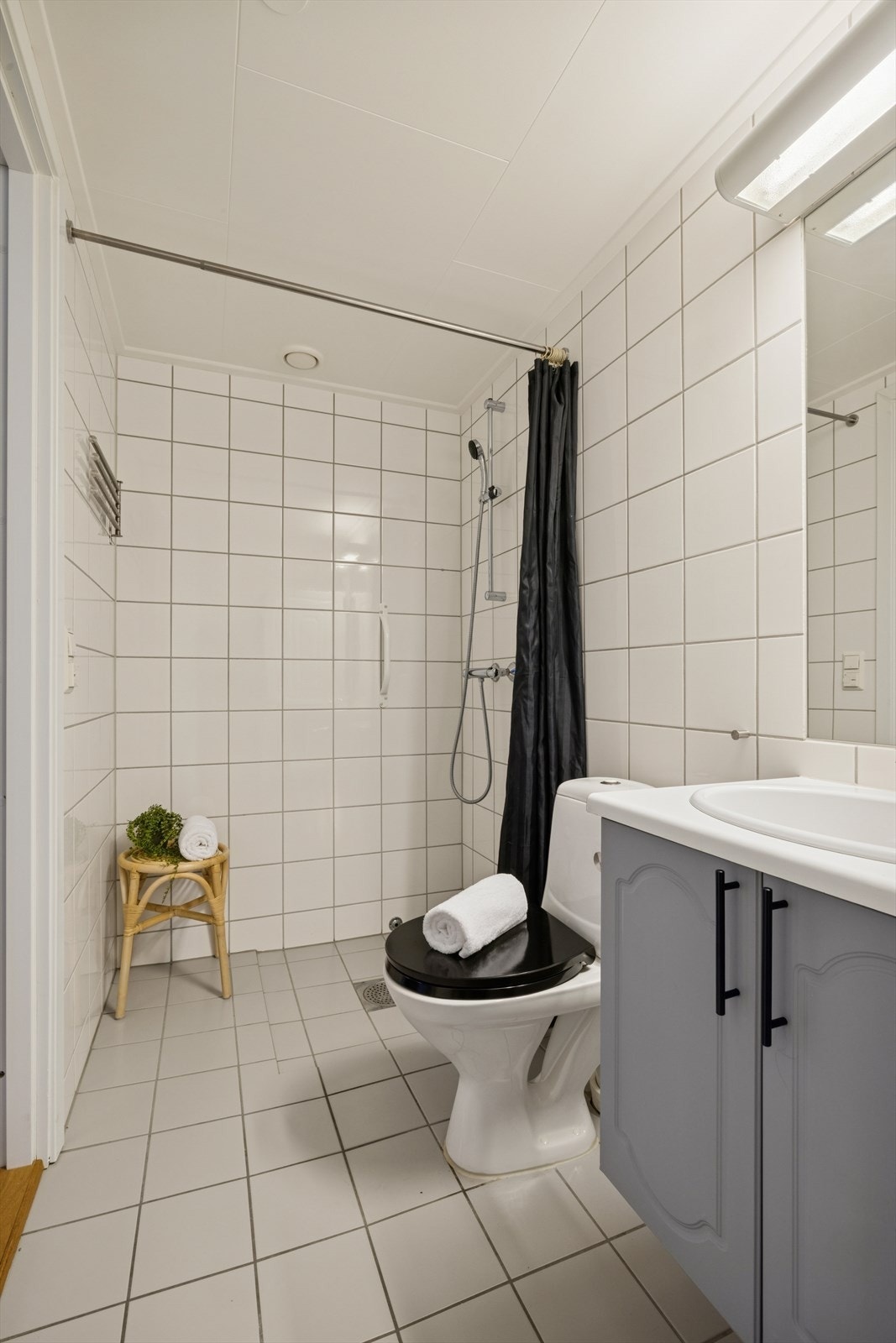 Rommet er innredet med en nedfelt servant, toalett og en dusj med forheng. Det er opplegg for vaskemaskin. Galleribilde