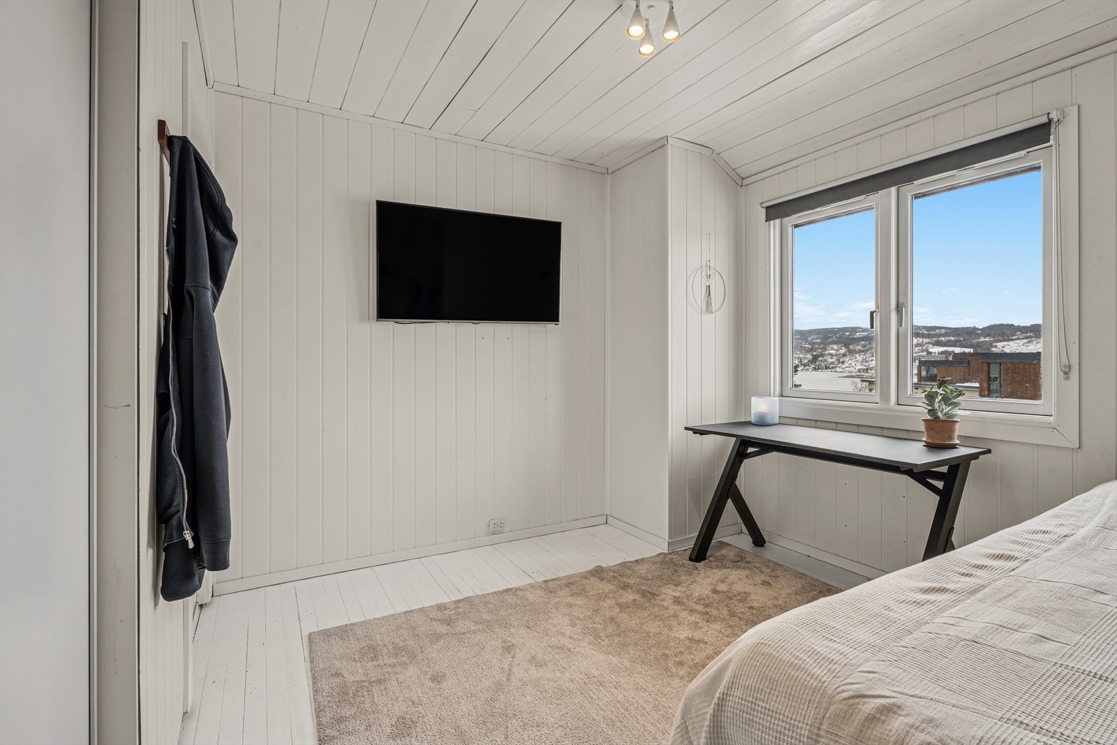 Soverommene er gjennomført i lyse og tidløse farger, og store vindusflater slipper inn rikelig med naturlig lys, noe som skaper en behagelig og avslappende atmosfære Galleribilde