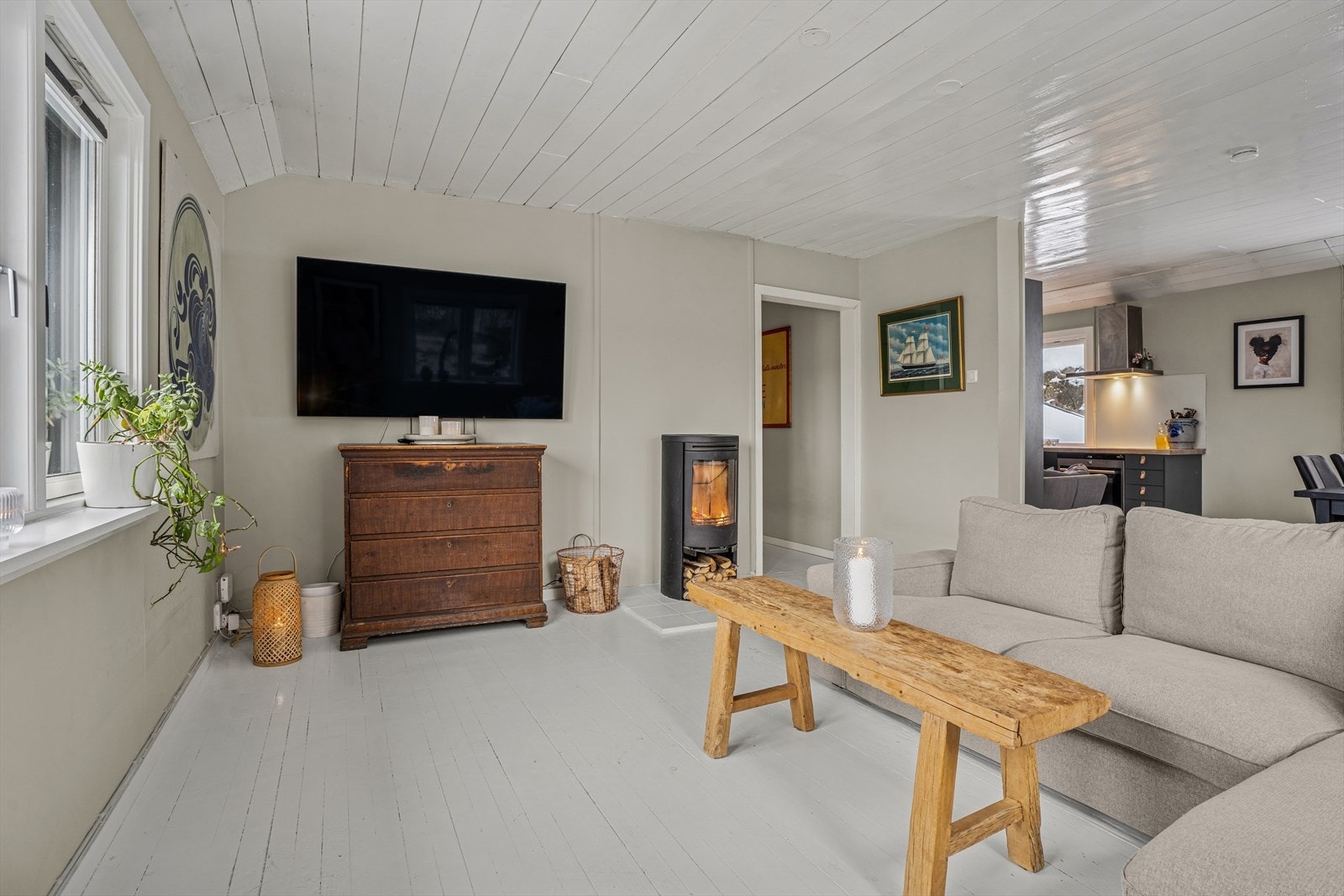 Stuen har god plass til både sofagruppe og spisestue, og deles naturlig inn i soner- en stemningsfull vedovn gir god atmosfære Galleribilde