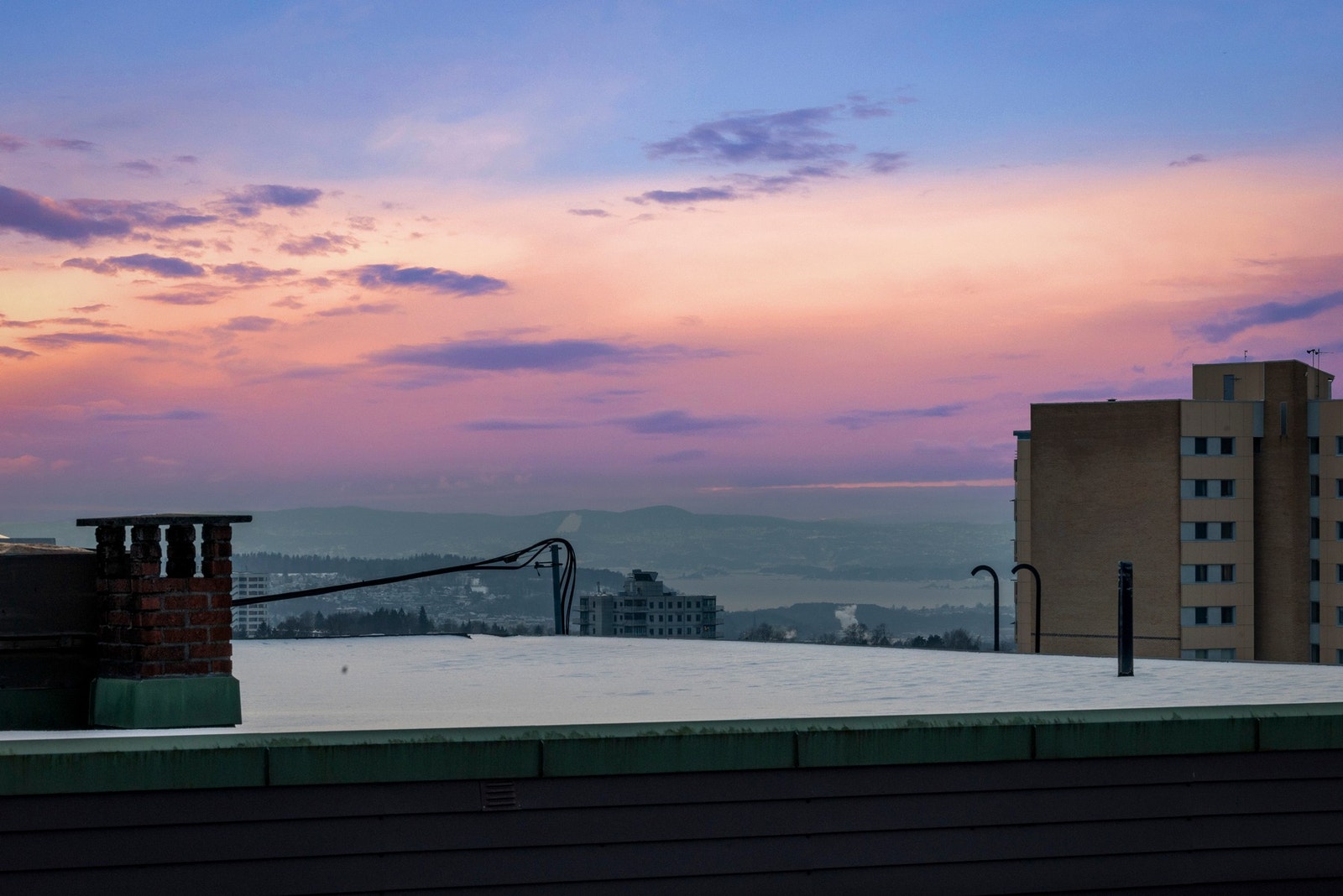 Over det ene taket kan du få et lite glimt av fjorden Galleribilde