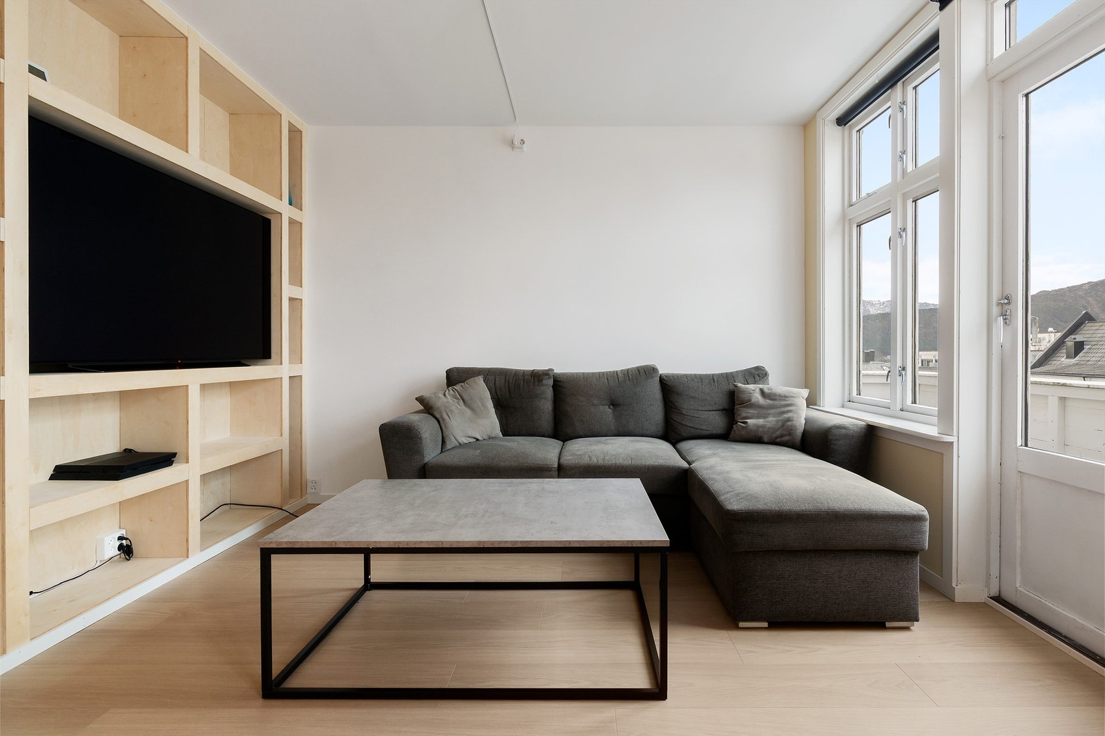 Stuen har lyse overflater og godt med naturlig lysinnslipp fra vinduer Galleribilde