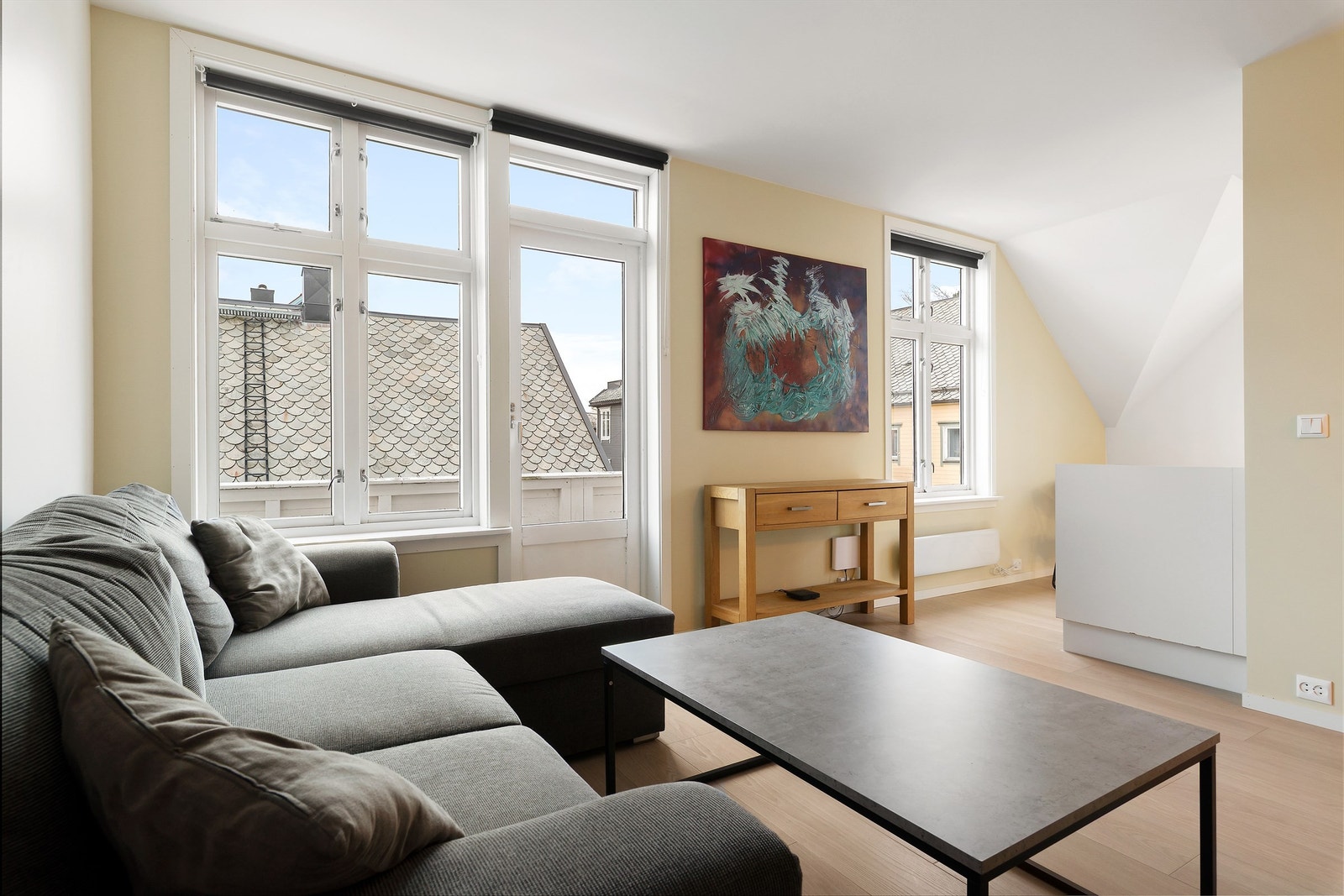 Stue med lyse overflater og åpen men likevel skjermet løsning mot kjøkken Foto: Diakrit (Krisztian Sere) Galleribilde