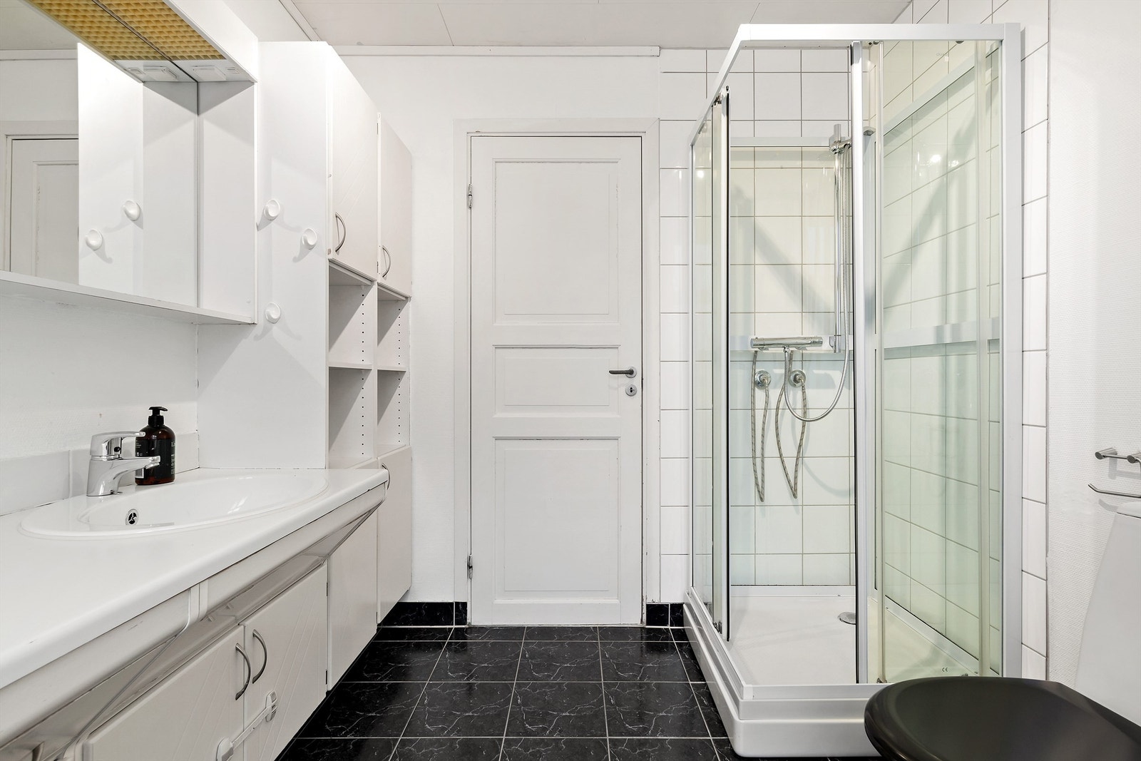 Dusjkabinett med dusjarmatur og gulvstaående toalett Galleribilde