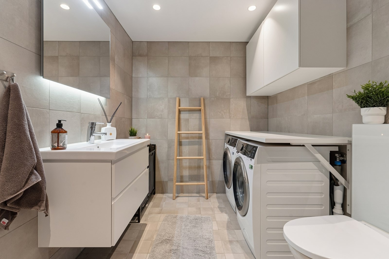 Flislagt baderom som varmes opp med elektriske varmekabler, noe som gir en behagelig varme året rundt. Innfelte downlights i himlingen sørger for jevn og god belysning som skaper et moderne og delikat uttrykk. Galleribilde