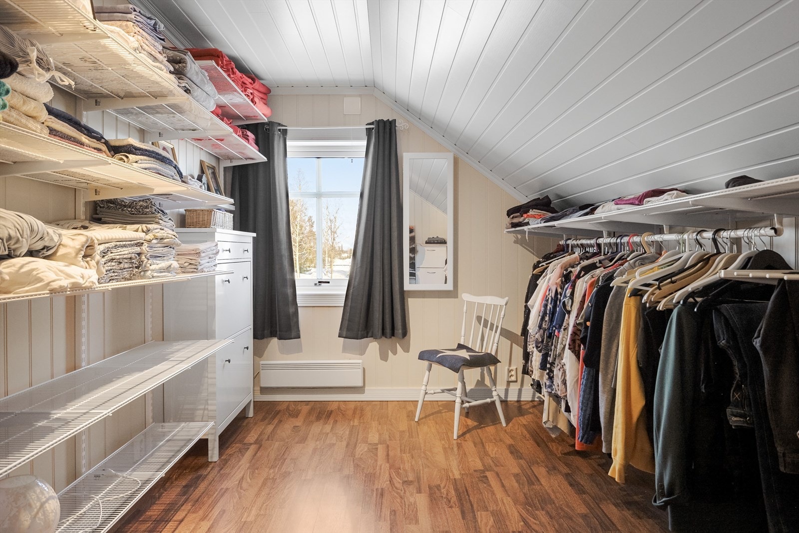 God standard med parkett på gulv, lyse paneplater på veggene og et stort vindu som slipper inn fint lys. Galleribilde