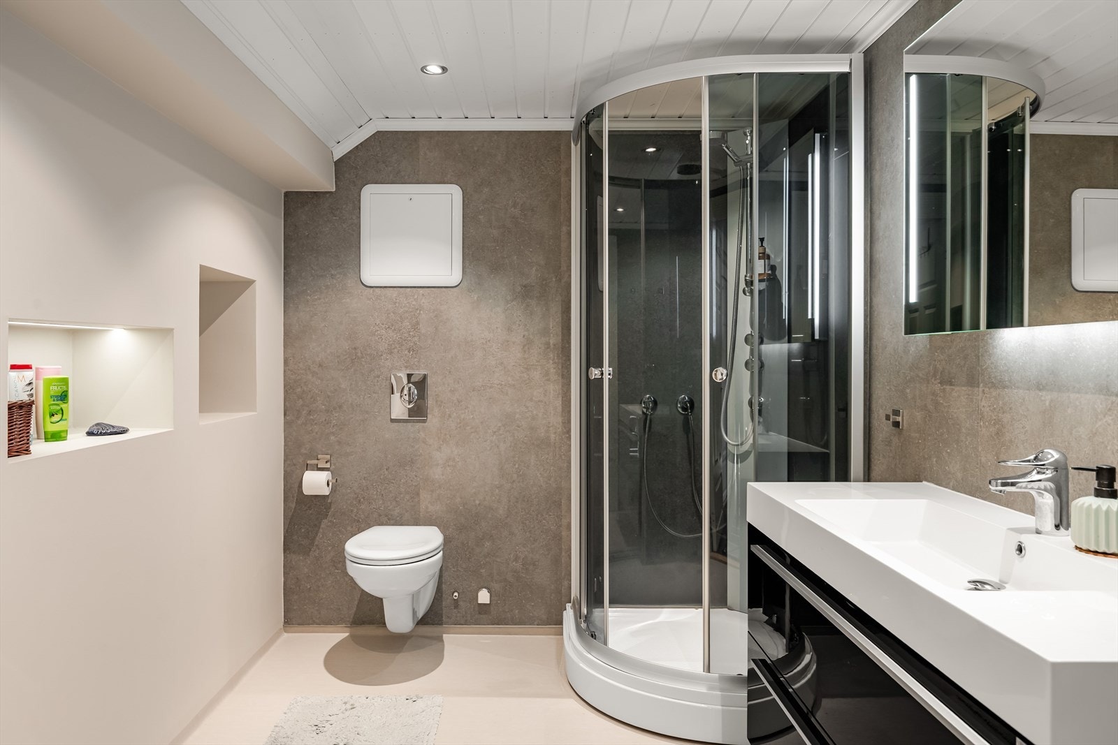 Moderne baderom i 2. etasje med våtromsbelegg på gulv, elektriske varmekabler, overflater med våtromsplater og malte plater, downlights og elektrisk styrt vifte i himlingen. Galleribilde