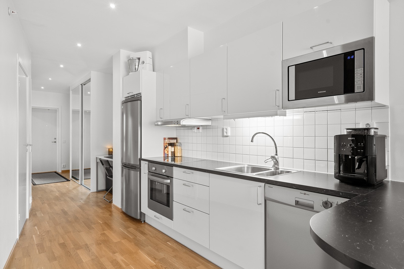 Fin kjøkkeninnredning med slette fronter og laminat benkeplate. Galleribilde