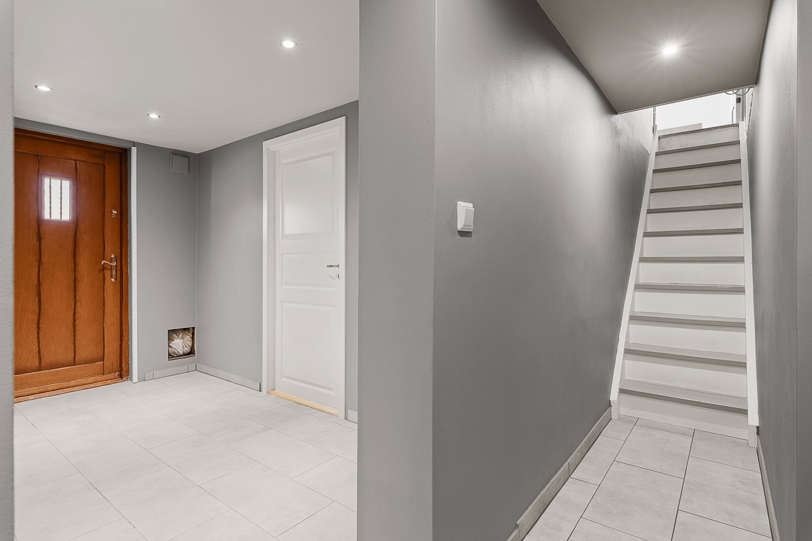 Trapp ned fra kjøkkenet til romslig gang i underetasje - Underetasjen er innredet og bruksendret uten søknad og er derfor ikke godkjent Galleribilde