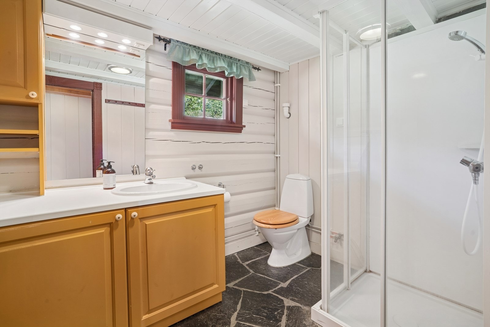 Badet er utsyrt med dusjkabinett, toalett og servant. Direkte tilkobling til badstue Galleribilde