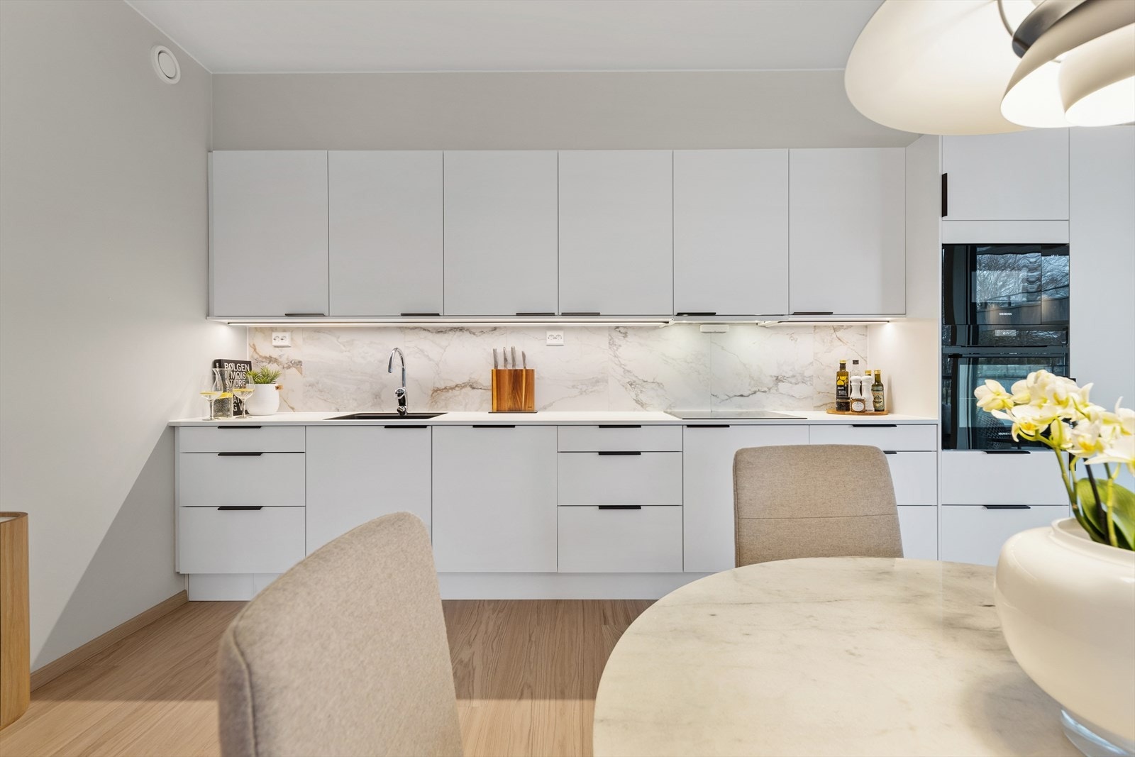 Kjøkkenet har en lys og tidløs utforming med slette, moderne fronter. Galleribilde