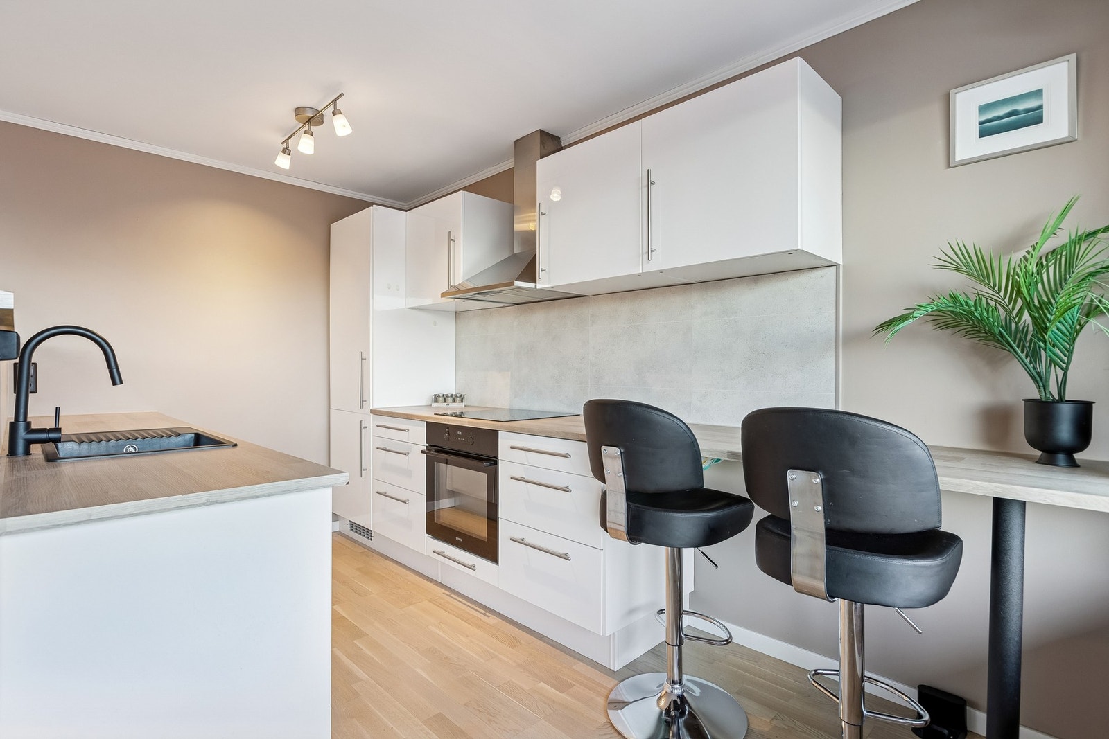 Kjøkkenet har delvis integrerte hvitevarer og praktisk belysning over benken. Galleribilde