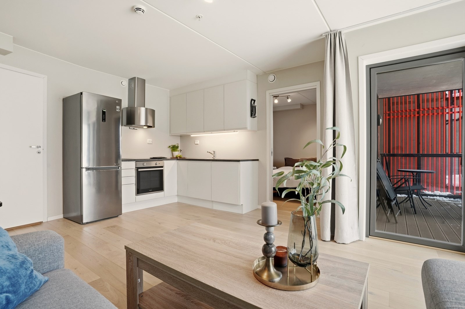 Lys og stilren stue med 1-stavs parkett på gulv og slette vegger malt i en lys fargetone. Galleribilde