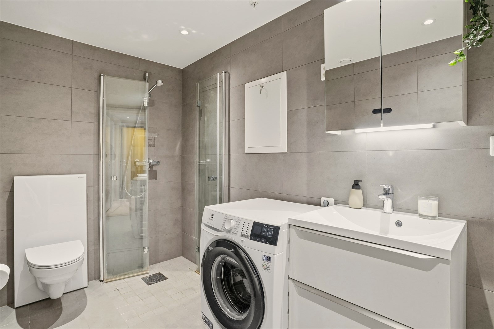 Badet er innredet med dusjhjørne, toalett og baderomsinnredning med servant. Det er opplegg for vaskemaskin. Galleribilde