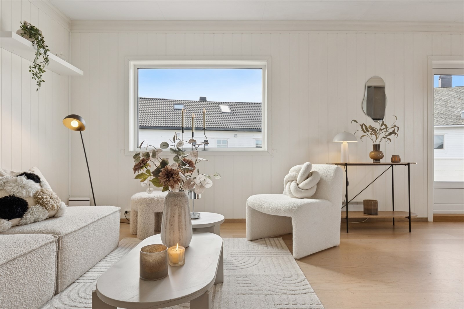 Gjennomgående parkett og lyse panelvegger skaper en helhetlig atmosfære i stuen. Galleribilde