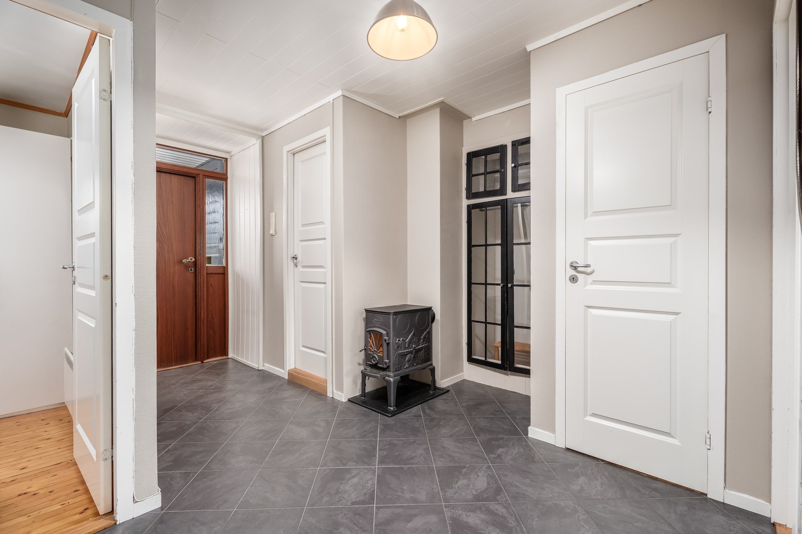 Inne i gangen er det en varm og god vedovn. I denne etasjen finnes det bad med wc, gjestetoalett og 3 soverom. Galleribilde