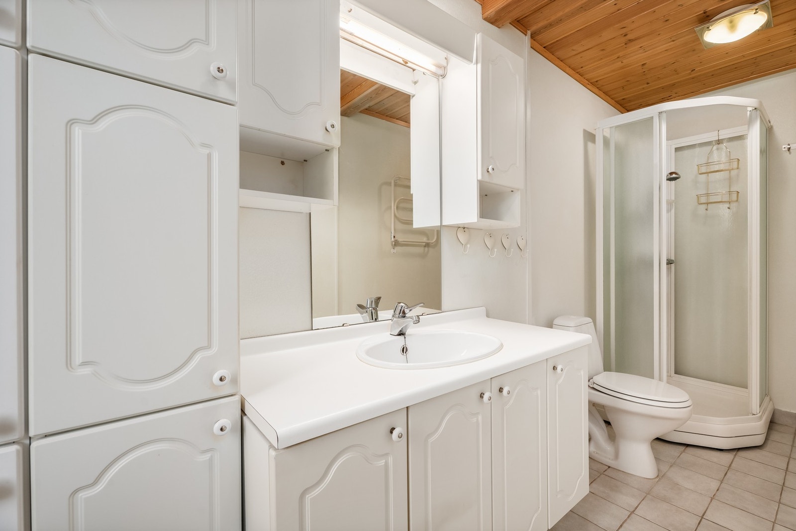 Badet er av eldre dato, med flislagt gulv, varmekabler, wc og kabinett. Galleribilde