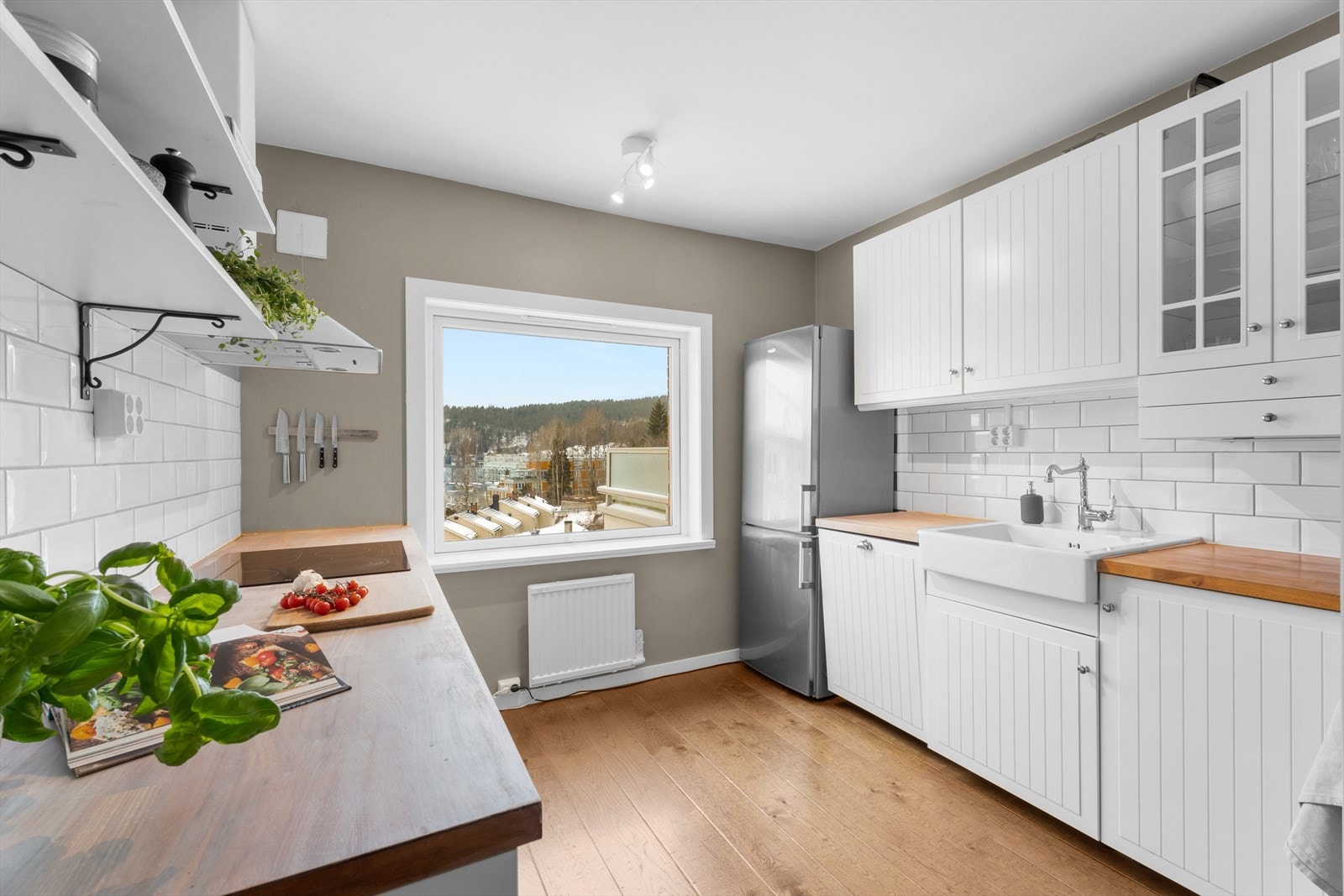 Kjøkkenet har profilerte fronter med benkeplate i heltre med nedfelt keramisk kum. Galleribilde