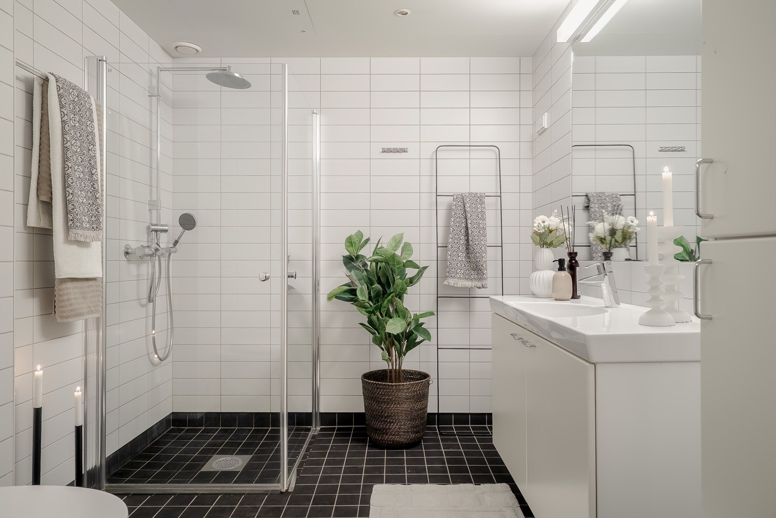 Lyst og romslig baderom utstyrt med dusjhjørne, servantinnredning og toalett. Galleribilde