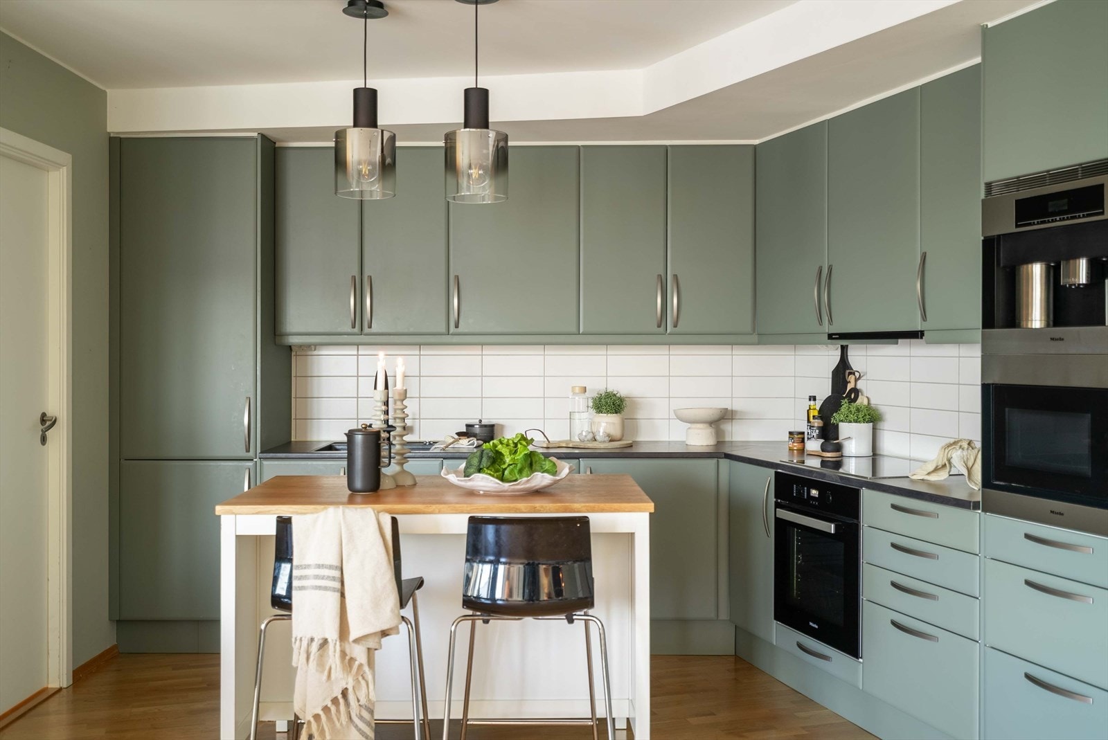 Et stilrent og gjennomført kjøkken med rolige fargetoner og god skapplass. Galleribilde