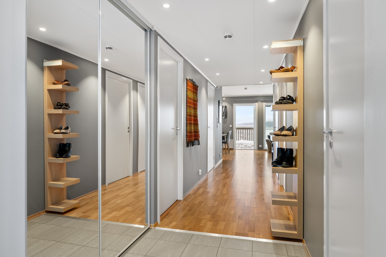 Ytterste del av entré er flislagt med varme. Skyvedørsgarderobe med speilfronter. Galleribilde