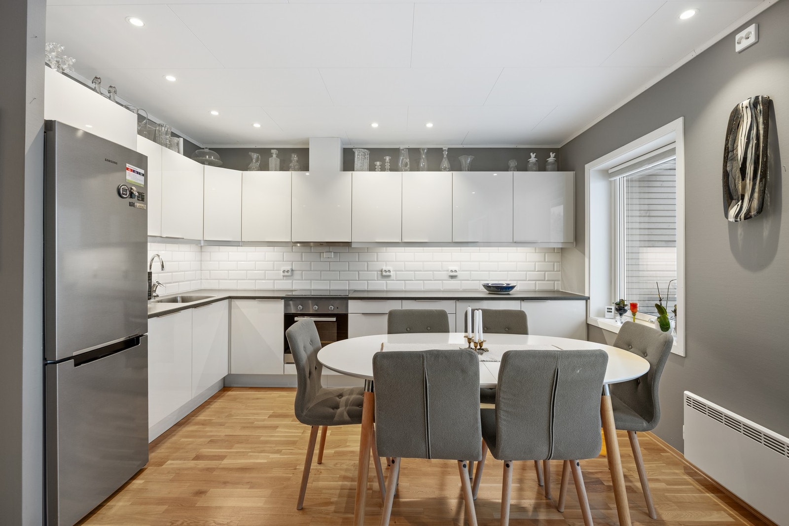 Stilren kjøkkeninnredning med integrert stekeovn, platetopp og oppvaskmaskin. Galleribilde