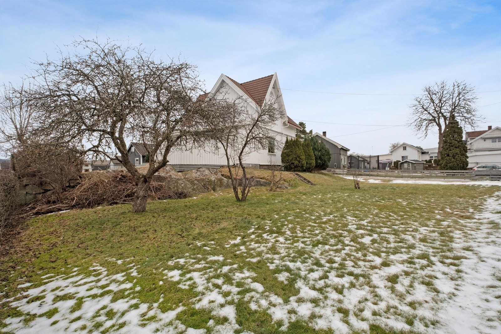 Det er pent opparbeidet hage med plener, busker, trær og beplantning. Fasade mot syd. Galleribilde