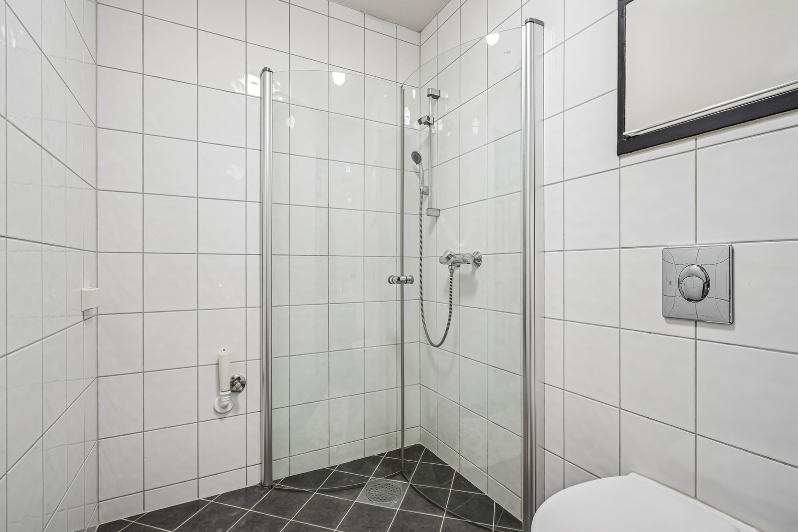 - dusjhjørne med glassdører og vegghengt toalett. Opplegg for vaskemaskin. Galleribilde