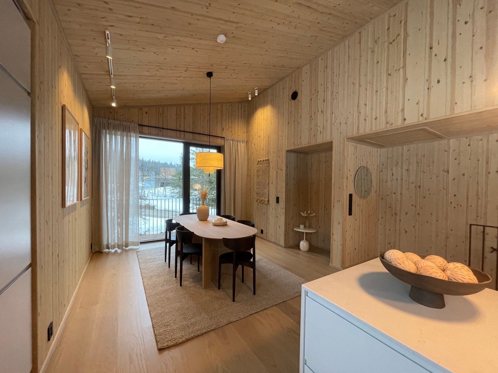 En gjennomgående oppholdssone med imponerende takhøyde på opptil 3,8 meter, store vindusflater (opp til 2,4 meters høyde) og balkong i hver ende. (Bilde av lik hytte på annen beliggenhet i prosjektet.) Galleribilde