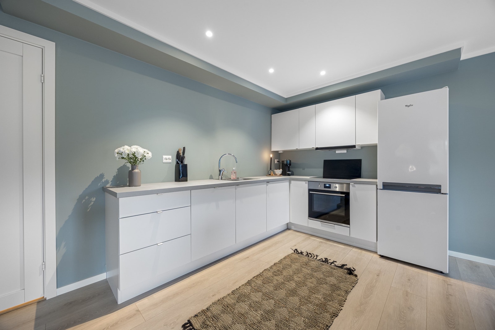 Kjøkkeninnredning med slette fronter, integrert oppvaskmaskin, stekeovn og koketopp. Galleribilde