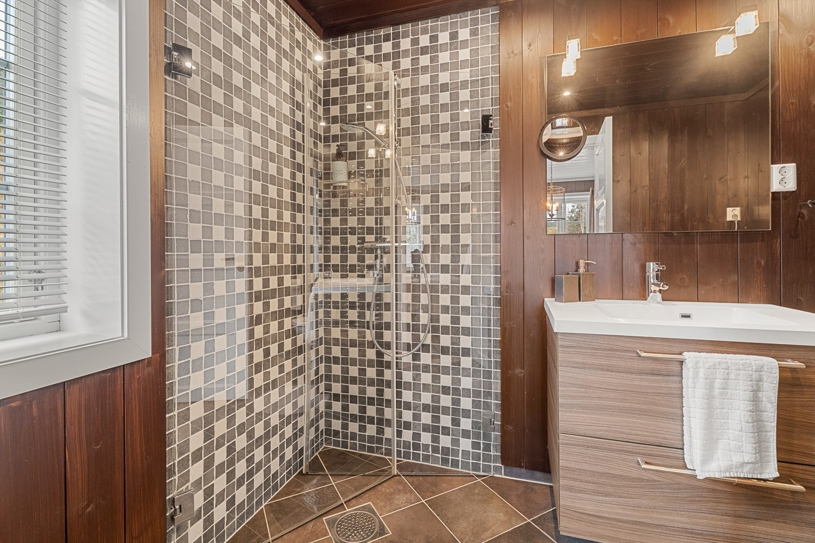 Badet er utstyrt med nedfelt servant, toalett, dusjvegger/hjørne, håndkletørker og opplegg for vaskemaskin. Galleribilde