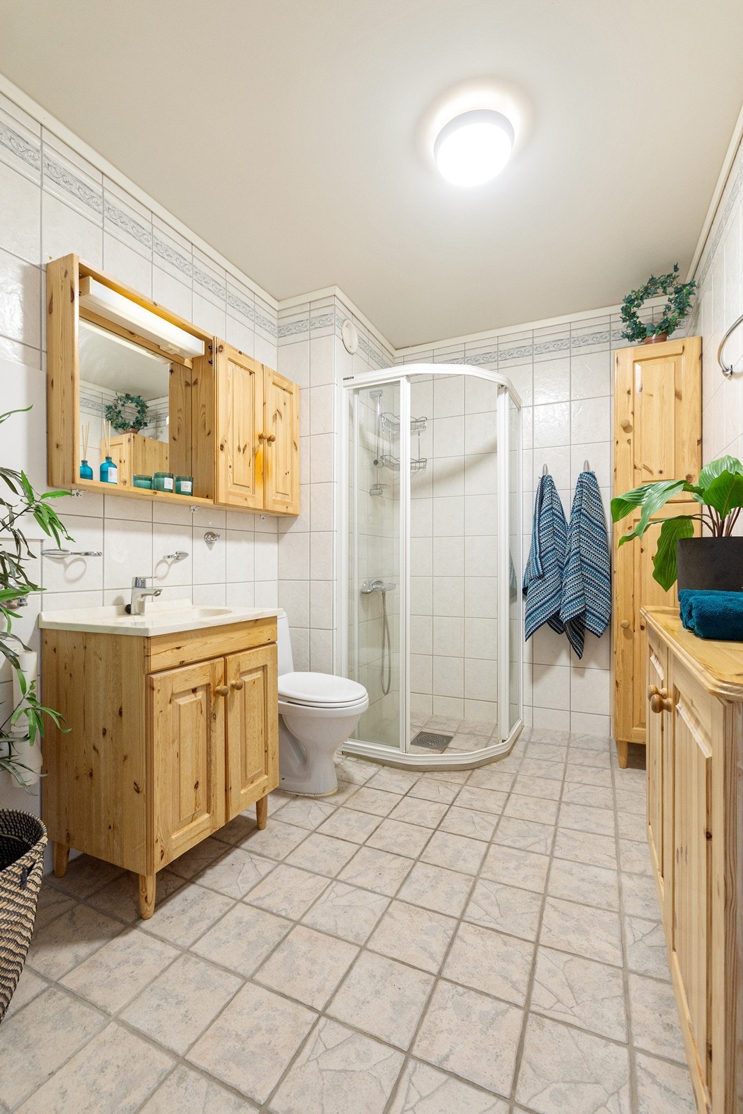 Badet er innredet med toalett, vegghnegt skap, servant i baderomsinnredning og dusjhjørne. Galleribilde