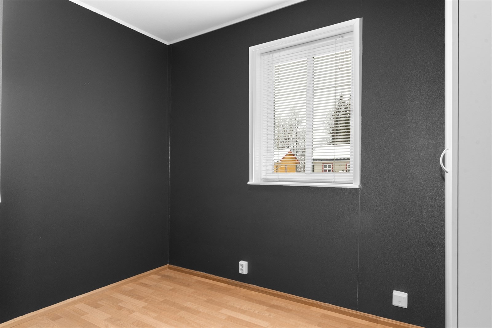 Soverommet er malt i en mørk gråfarge og det er laminat på gulvet. Galleribilde