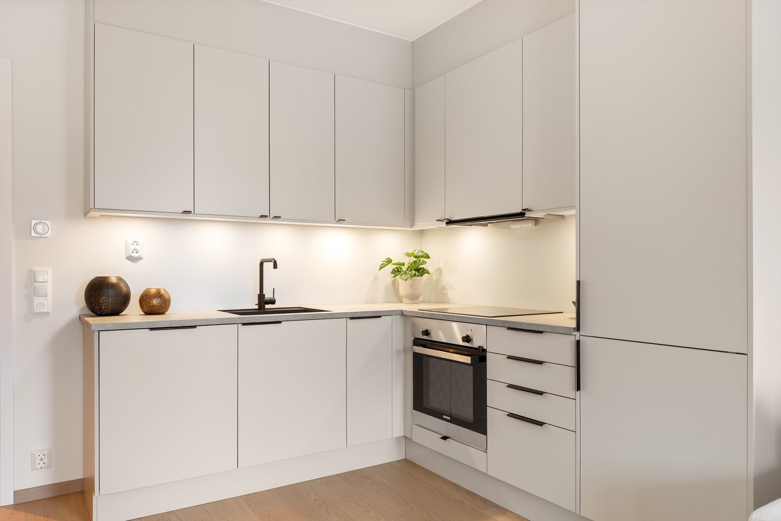 Laminat benkeplate med underlimt oppvaskkum fra Franke og ettgreps armatur fra Mora. Spotter innfelt i overskap gir godt arbeidslys og det er mekanisk avtrekksvifte over stekesonen. Galleribilde