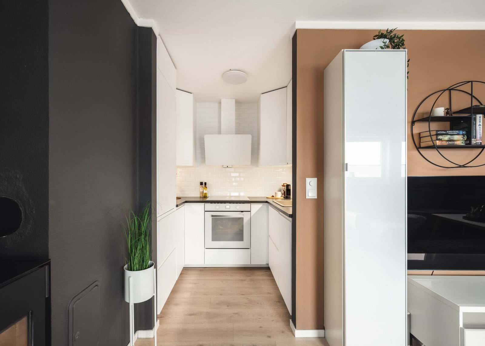 Kjøkkenet fremstår stilrent og tidløst med hvite fronter og laminat benkeplate. Galleribilde