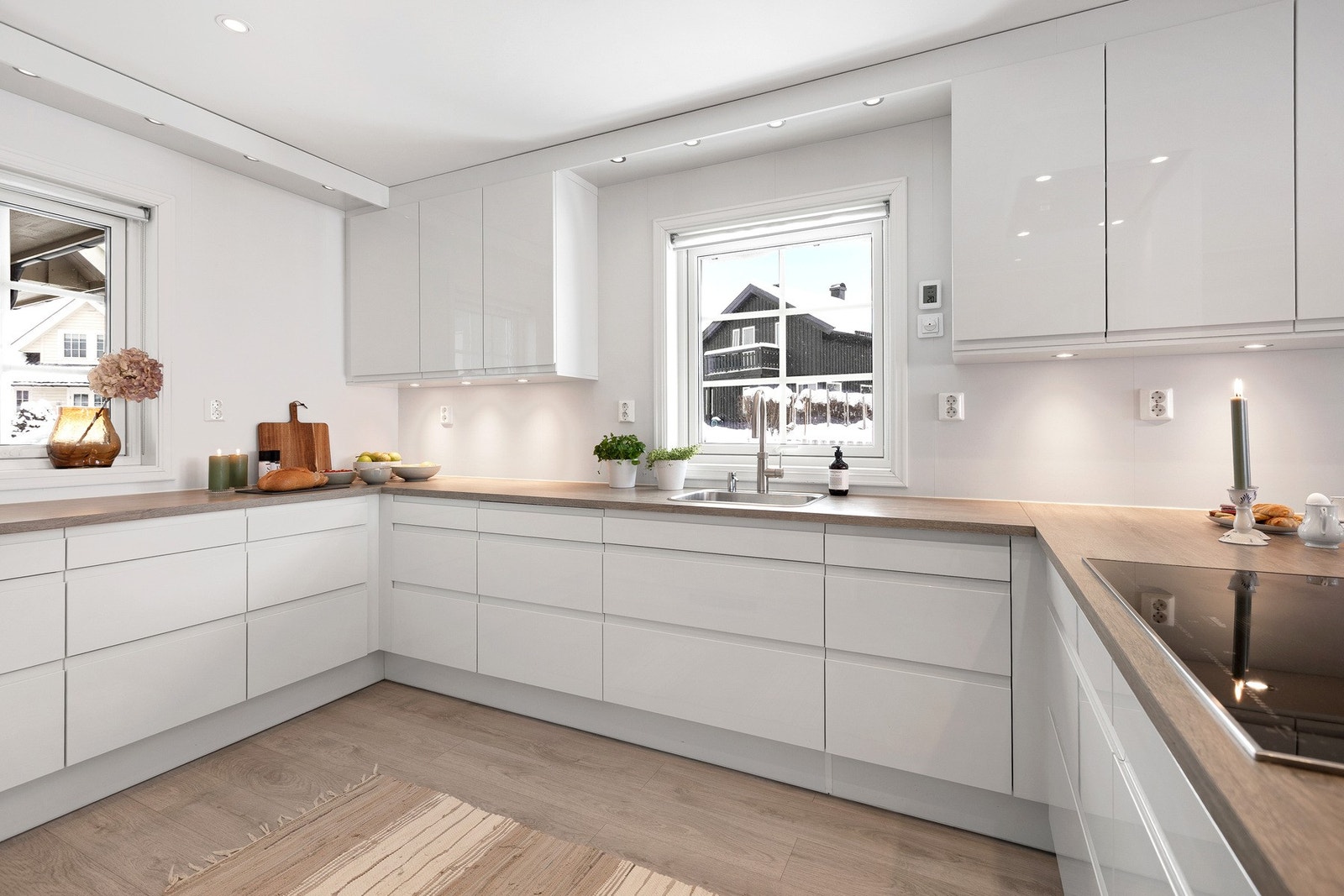 Kjøkkenet har en moderne og stilren innredning med glatte, lyse fronter og en praktisk utforming som gir rikelig med skap- og benkeplass. Galleribilde