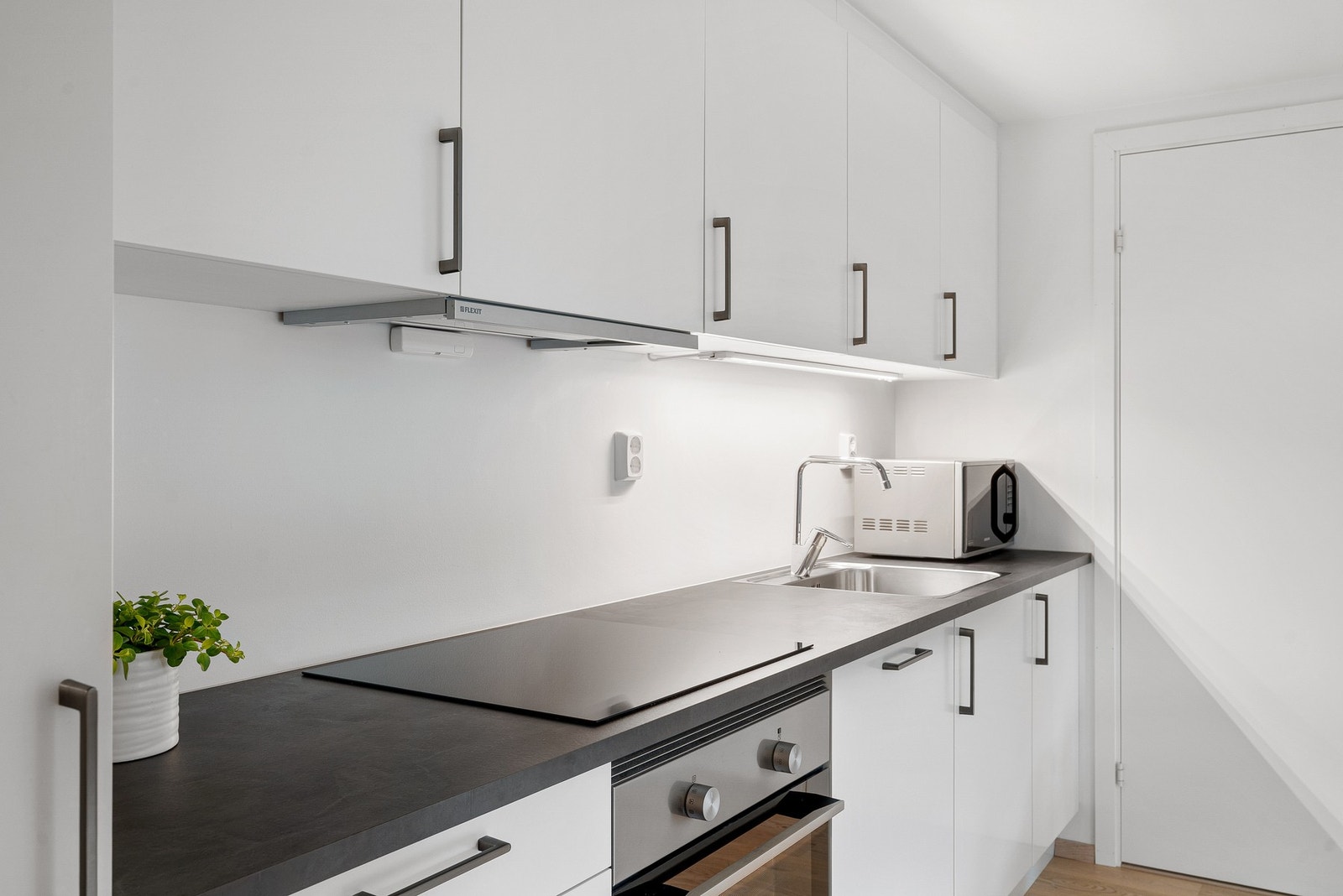 Et funksjonelt og velutstyrt kjøkken med god skapplass og praktiske arbeidsflater. Galleribilde