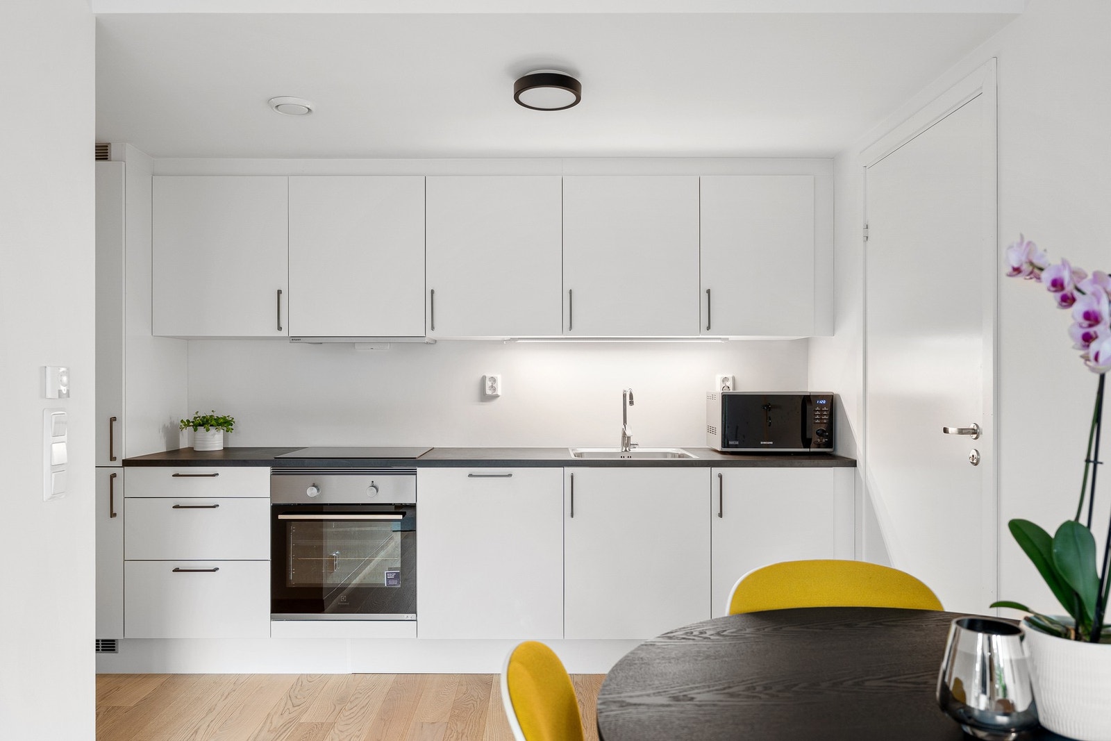 Tidløst kjøkken med integrerte hvitevarer som stekeovn, platetopp samt kjøle- og fryseskap. Galleribilde