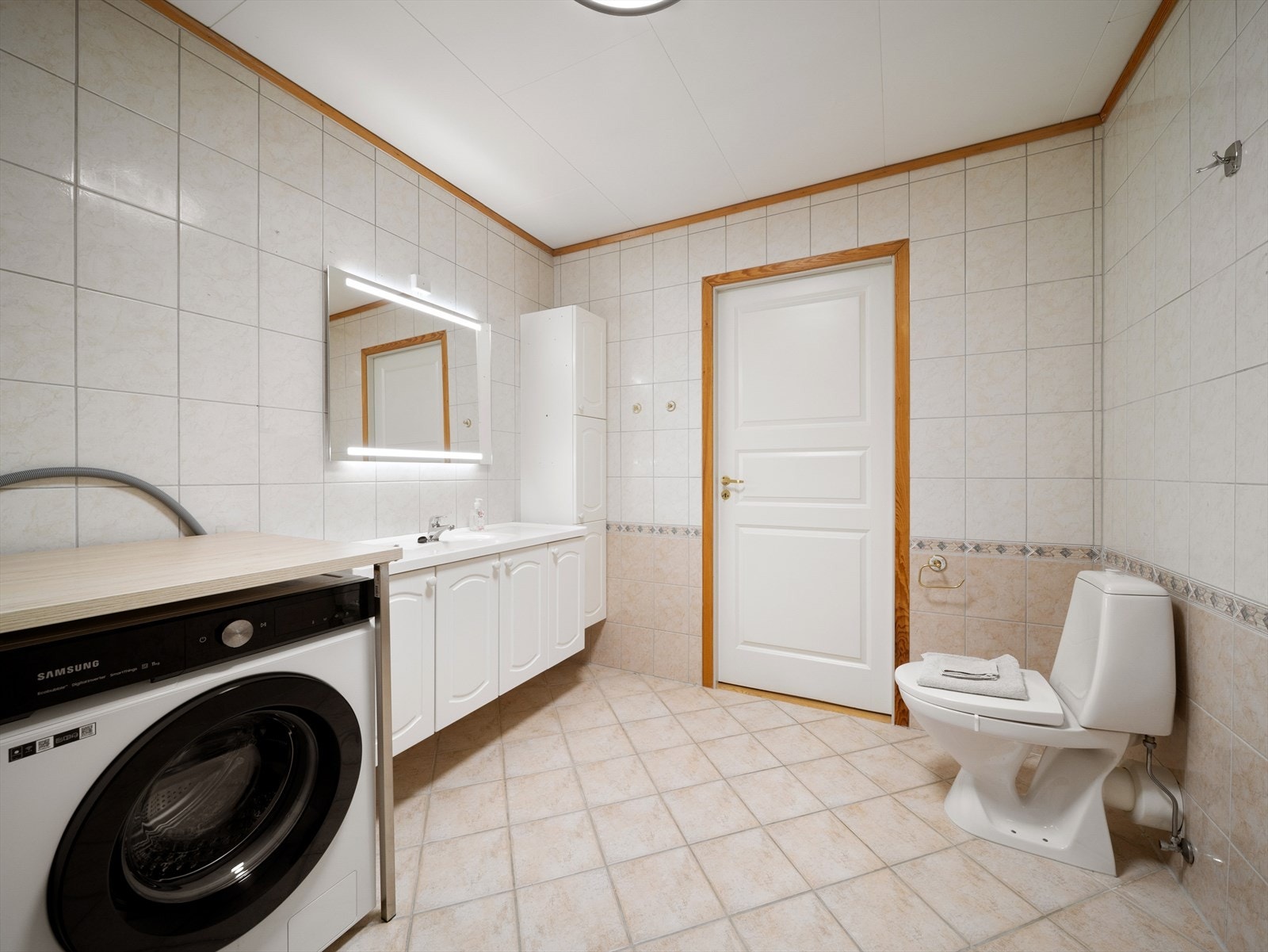 Badet er av god størrelse og innredet med dusj, toalett og baderomsmøbel med servant og speil med integrert belysning. Galleribilde