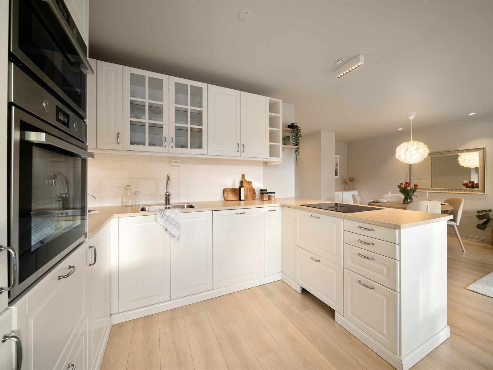 Kjøkkenet er fra Ikea (2023) i hvit, profilert utførelse med laminat benkeplate Galleribilde