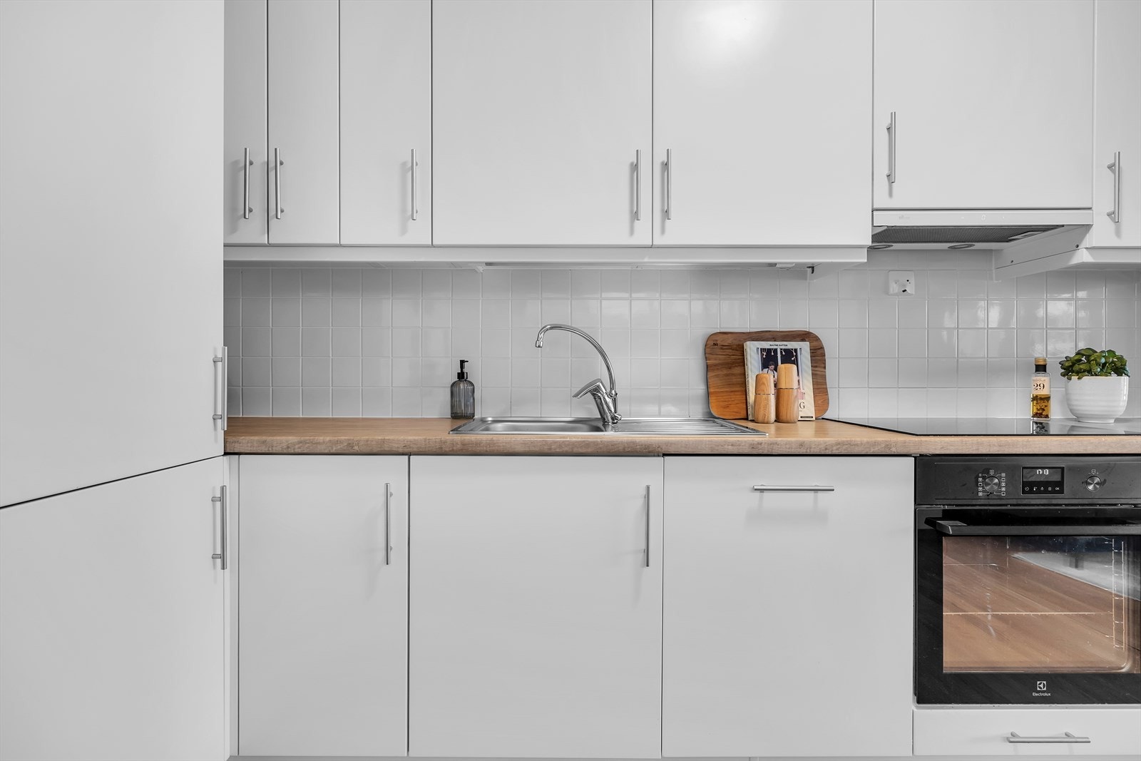 Stilrent kjøkken med hvite slette fronter Galleribilde