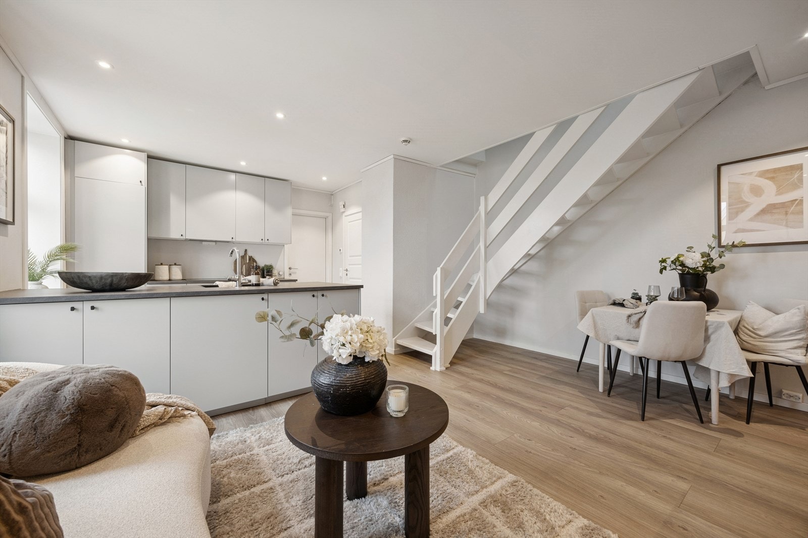 Selv med åpen løsning så får du en naturlig avgrensning mellom stue og kjøkken. Her er det god plass til spisebord på stuen. Galleribilde