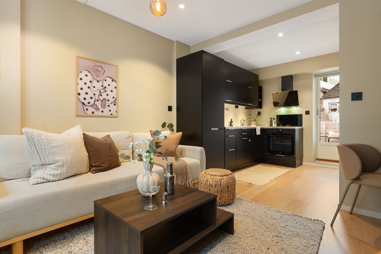 Den åpne stue- og kjøkkenløsningen skaper en naturlig, sosial sone i leiligheten - perfekt for både hverdagsliv og hyggelige sammenkomster Galleribilde