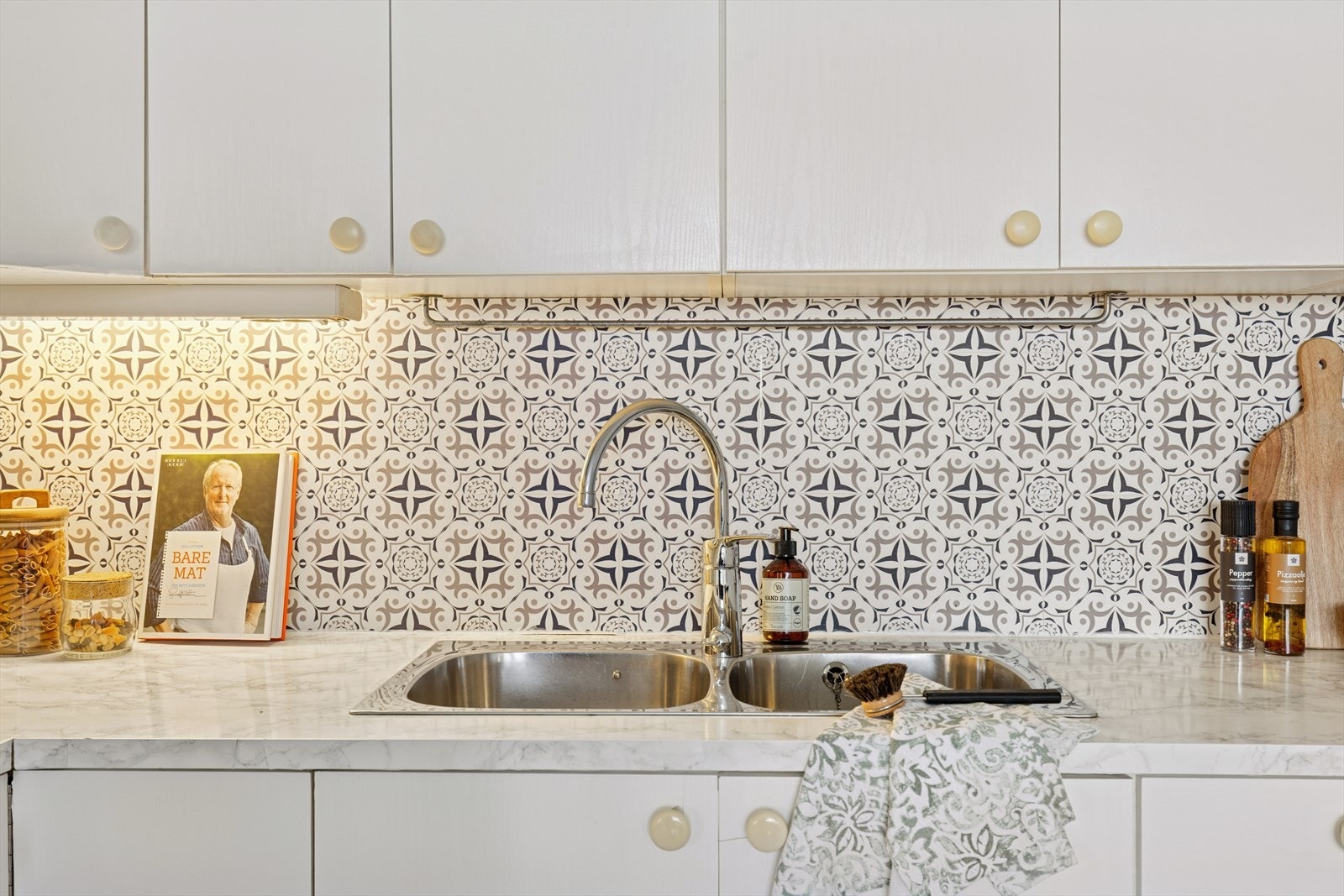 Kjøkkeninnredning med glatte fronter. Benkeplate i laminat. Nedfelt kum av stål med blandebatteri Galleribilde