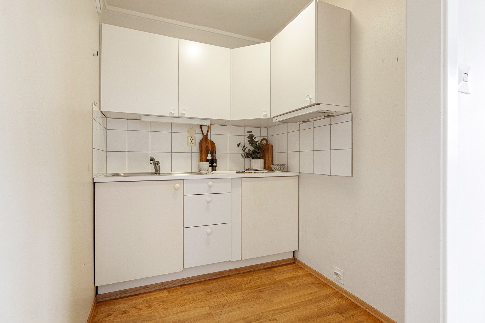 Eldre kjøkken. Enkel og funksjonell utforming med rette fronter i hvit utførelse Galleribilde