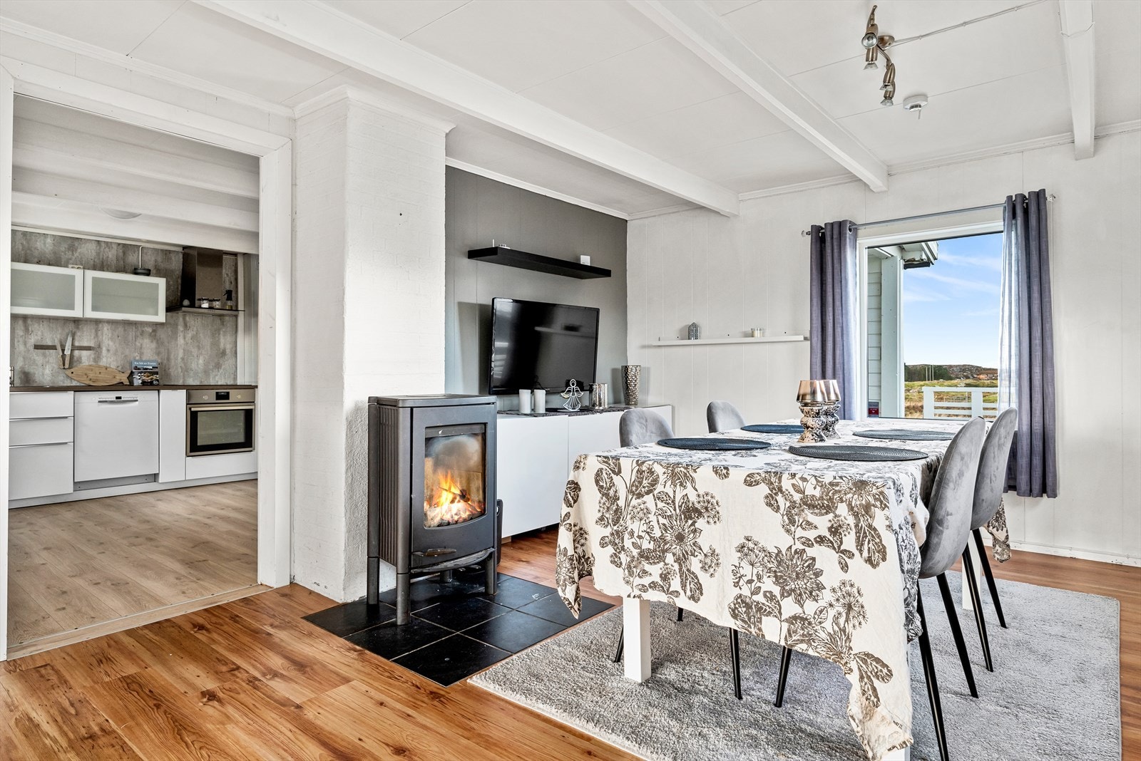 Lys og koselig spisestue med vedfyringsovn som skaper en varm og innbydende atmosfære. Galleribilde