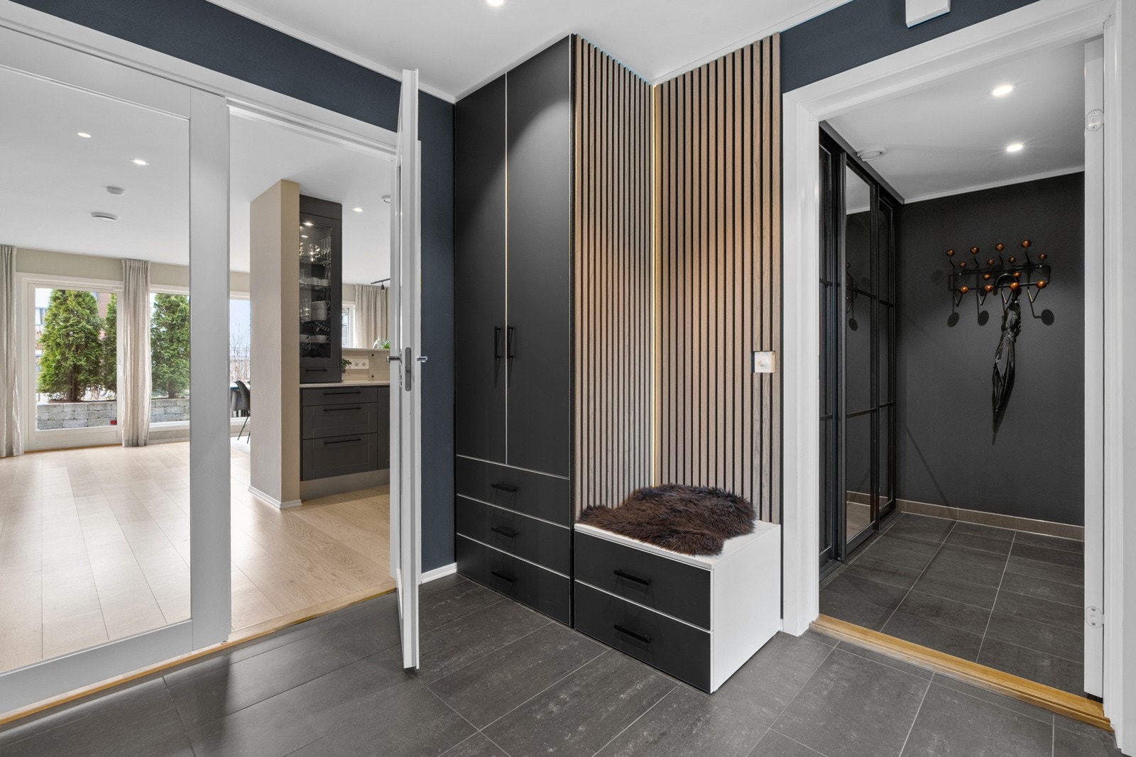 Det første som møter deg når du kommer inn i boligen er en moderne og innbydende entré. Mellom stue/kjøkken og entrè er det satt inn en tofløyet dør med glass for lysinnslipp. Galleribilde