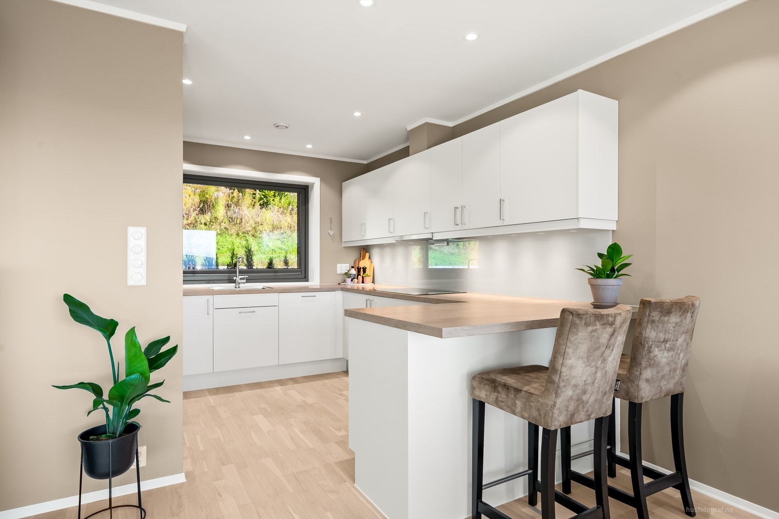 Moderne og tidløs kjøkkeninnredning fra kvalitetsprodusenten Sigdal med hvite slette fronter og benkeplate av laminat med nedfelt oppvaskkum. Galleribilde