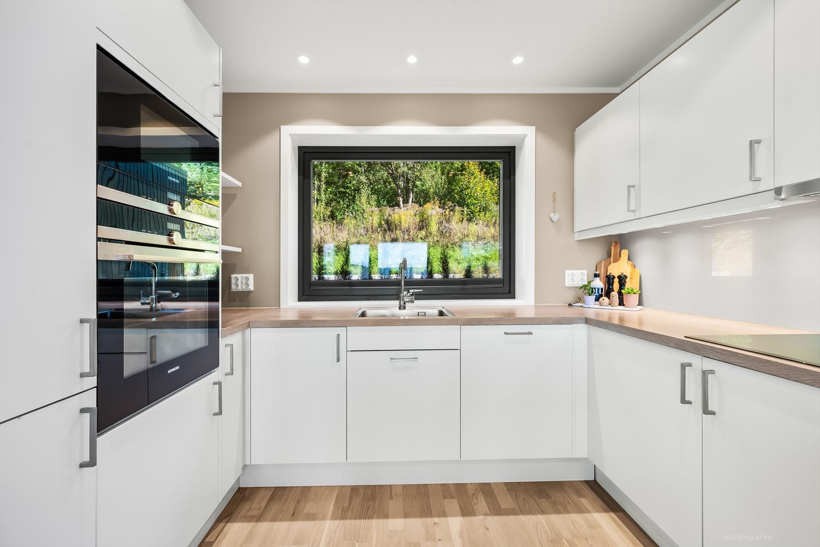 Kjøkkenet har rikelig med skapplass og benkeplass, noe som gir både praktisk oppbevaring og god arbeidsflate til matlaging. Galleribilde