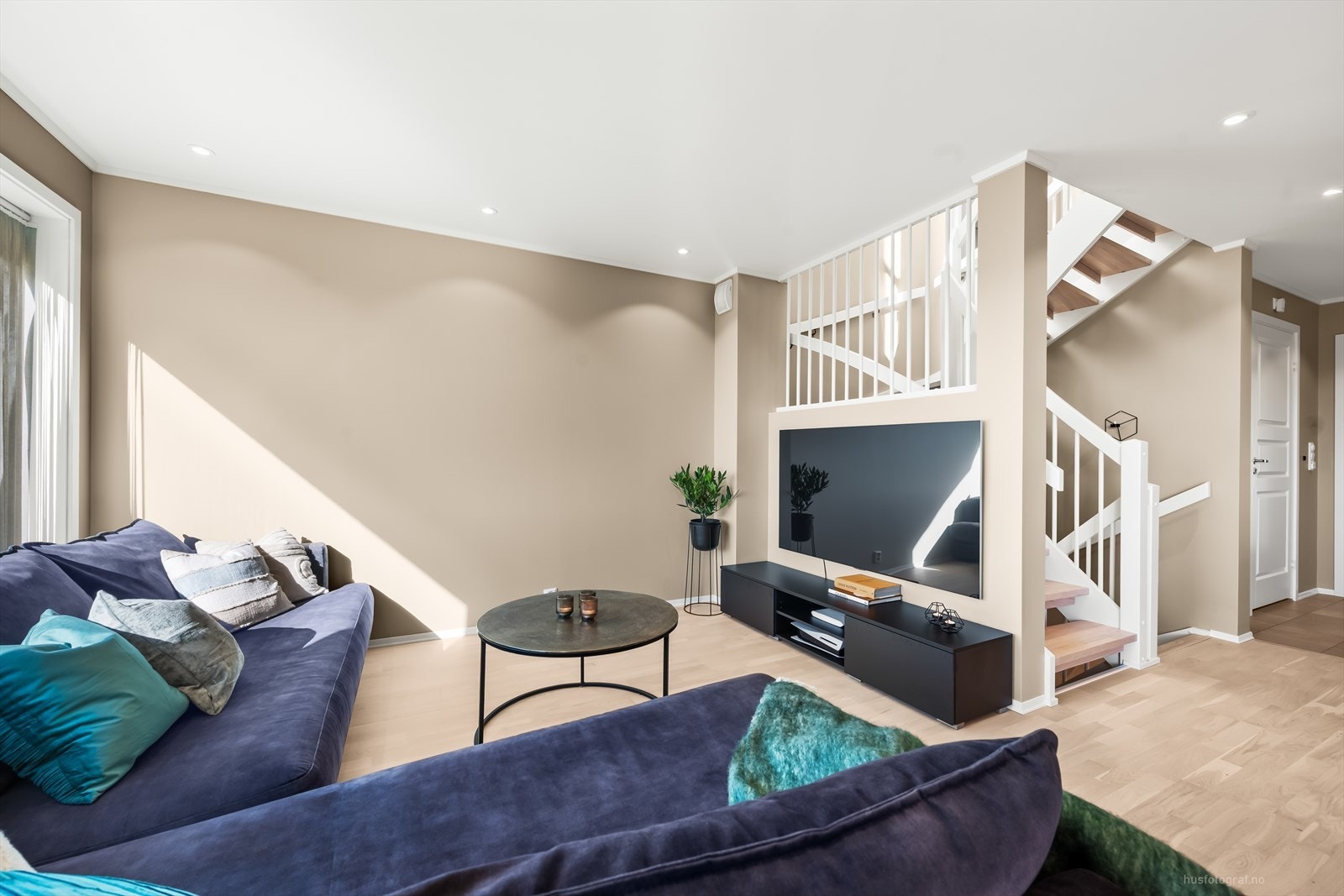 Den lyse og innbydende stuen har pene overflater med parkett på gulv og lyse slette vegger, som gir et moderne uttrykk. Galleribilde