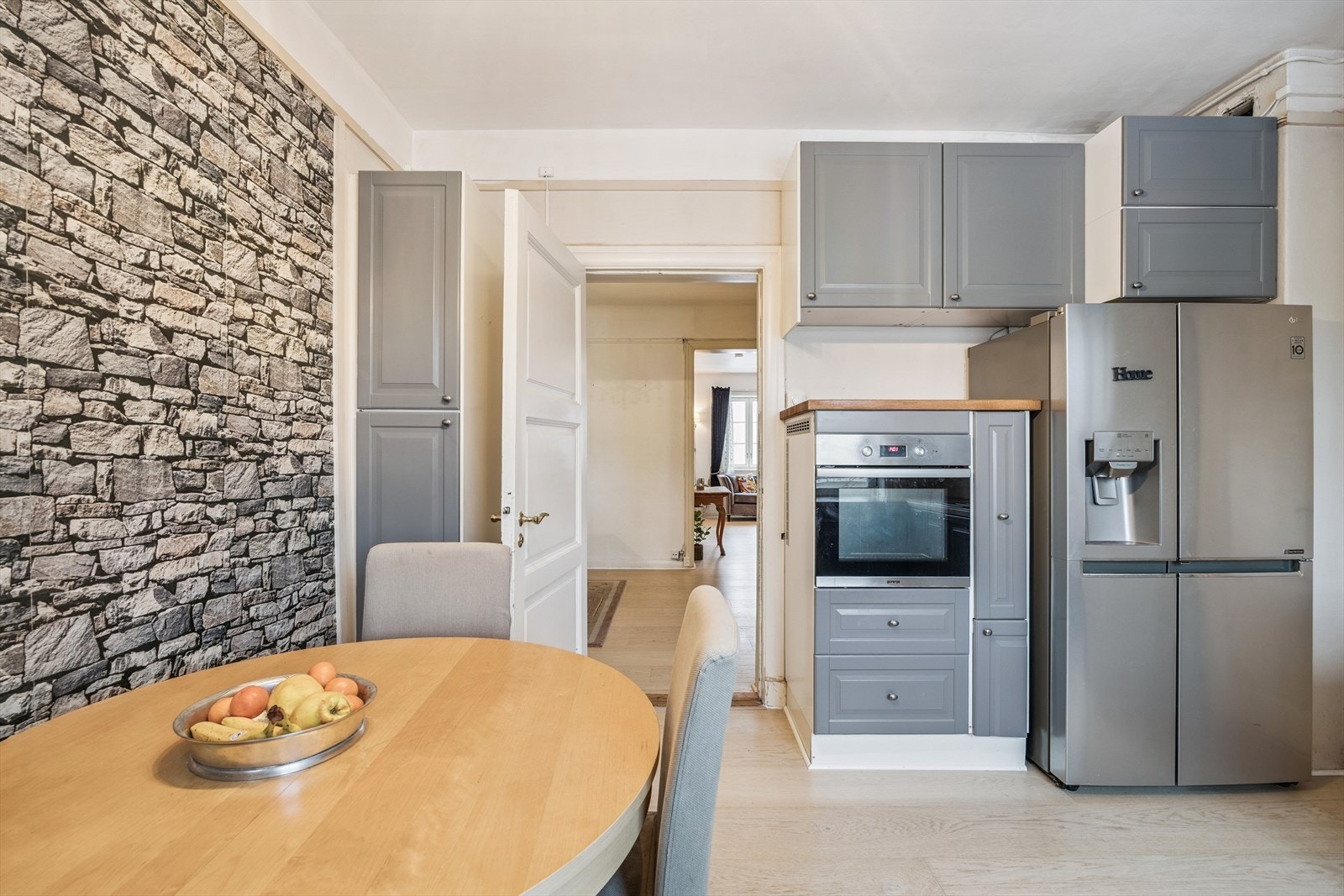 Kjøkken med spiseplass og kjøkkeninnredning m/nedfelt induksjonstopp, integrert oppvaskmaskin og stekeovn. Løst side by side kjøl/frys i egen nisje. Galleribilde